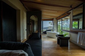 Un interior moderno con un sofá, una bañera y vistas al exterior.