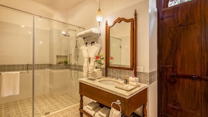 A bathroom with a glass shower enclosure, a wooden vanity with a marble countertop, and a large mirror. - Ama Stays And Trails Cardozo House (Candolim)