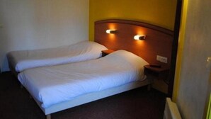 A double bed with a wooden headboard and two bedside lamps. - Comfort Hotel Emerainville Marne-la-vallee (Emerainville)