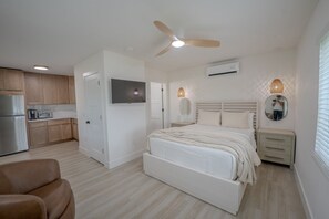 A bedroom with a bed, bedside table, and a ceiling fan. - 18 On the Bay Suite #5 (Indian Rocks Beach)