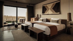 A hotel room with two beds, a desk, a chair, a large window, and a view of the outdoors. - Casa Cook El Gouna (El Gouna)