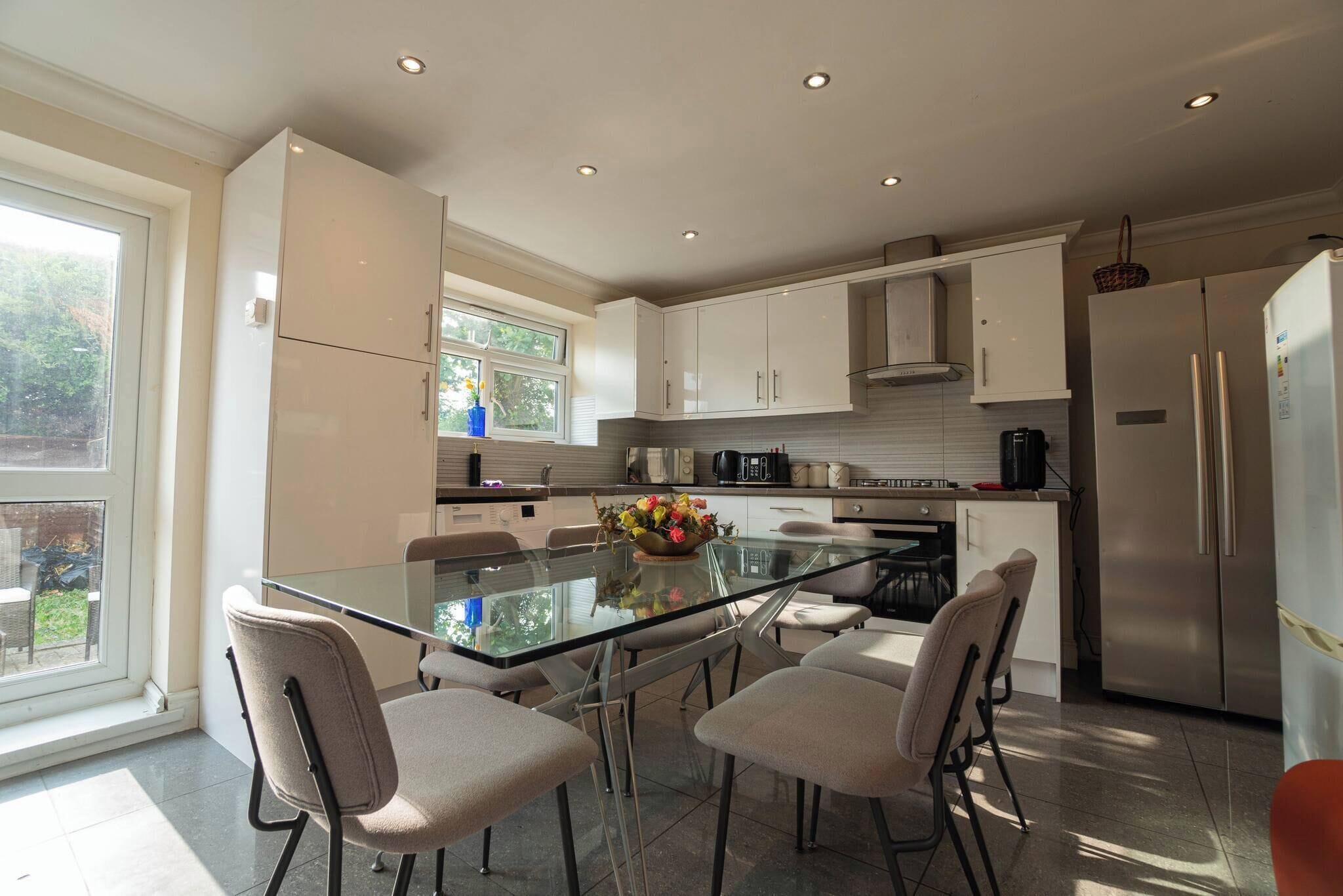 A modern kitchen with a central island, stainless steel appliances, and a view of the outdoors.