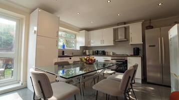 A modern kitchen with a central island, stainless steel appliances, and a view of the outdoors.