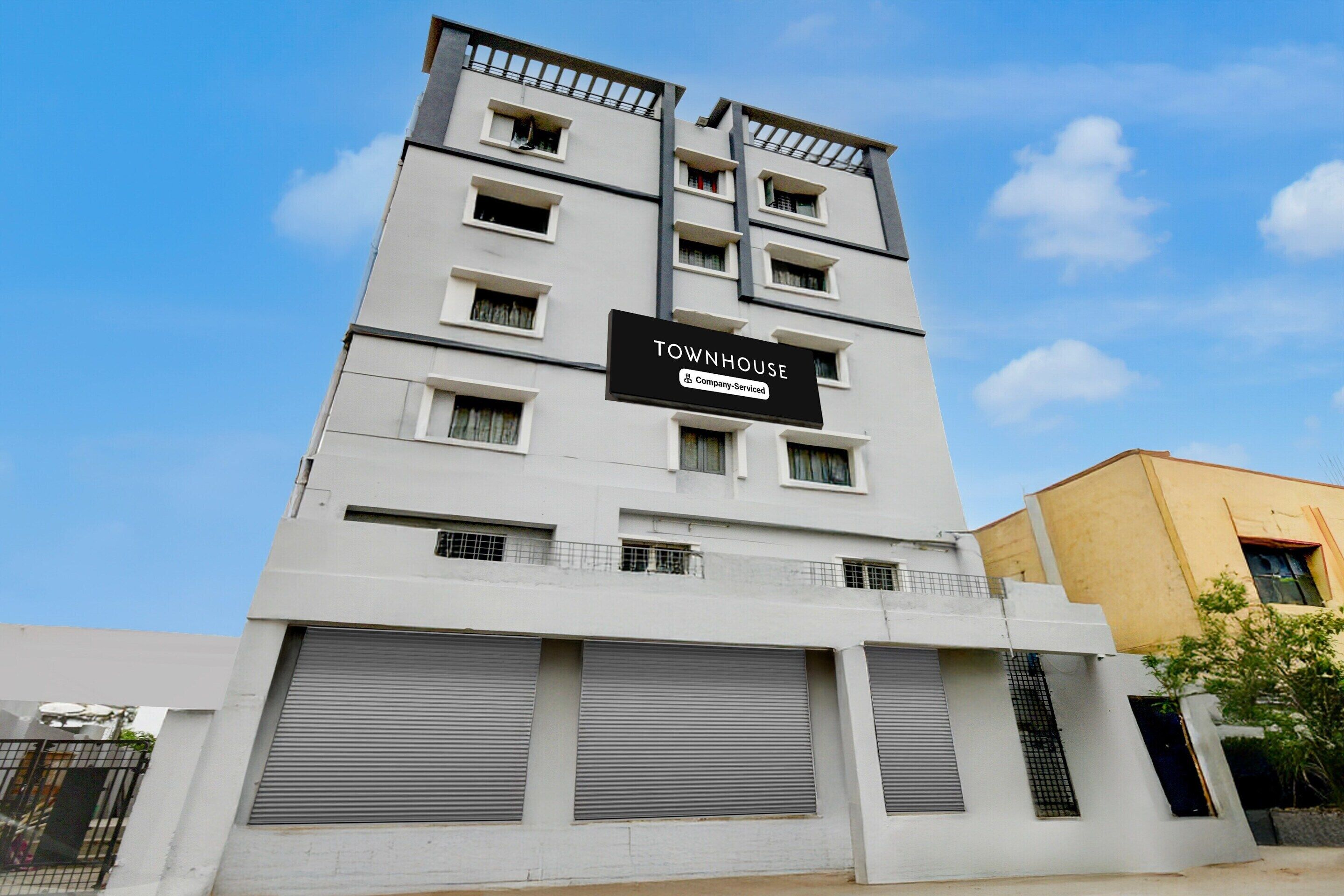 Un edificio de varios pisos con un letrero que indica que es una casa adosada con servicios de empresa.