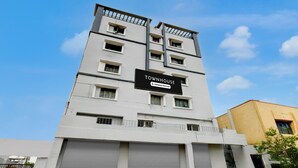 A multi-story building with a sign indicating it is a company-serviced townhouse. - Premium Vanasthalipuram Near (Hyderabad)