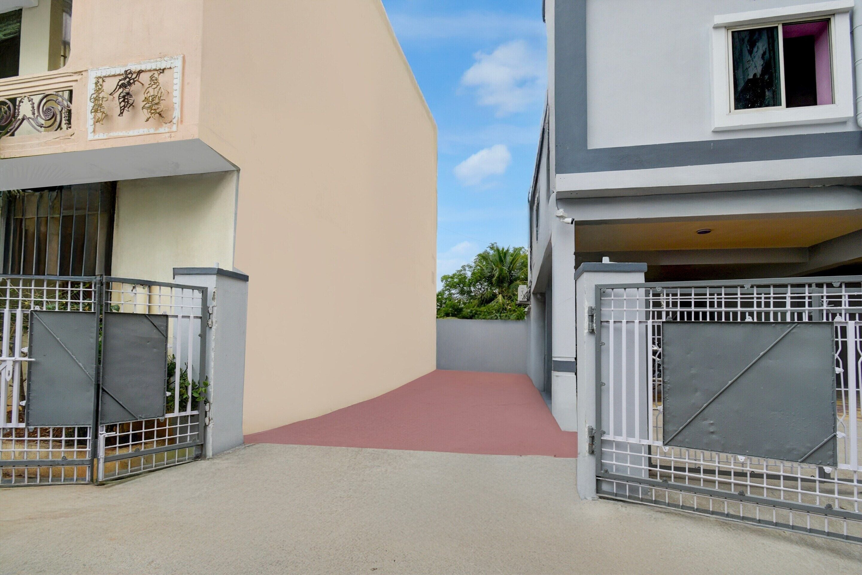 Ein verschlossener Eingang zu einem Wohngebäude mit einer geschwungenen Fassade und einem roten Weg zum Eingang.