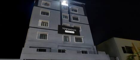 Un immeuble à plusieurs étages portant une enseigne indiquant : « TOWNHOUSE, services d’entreprise ».