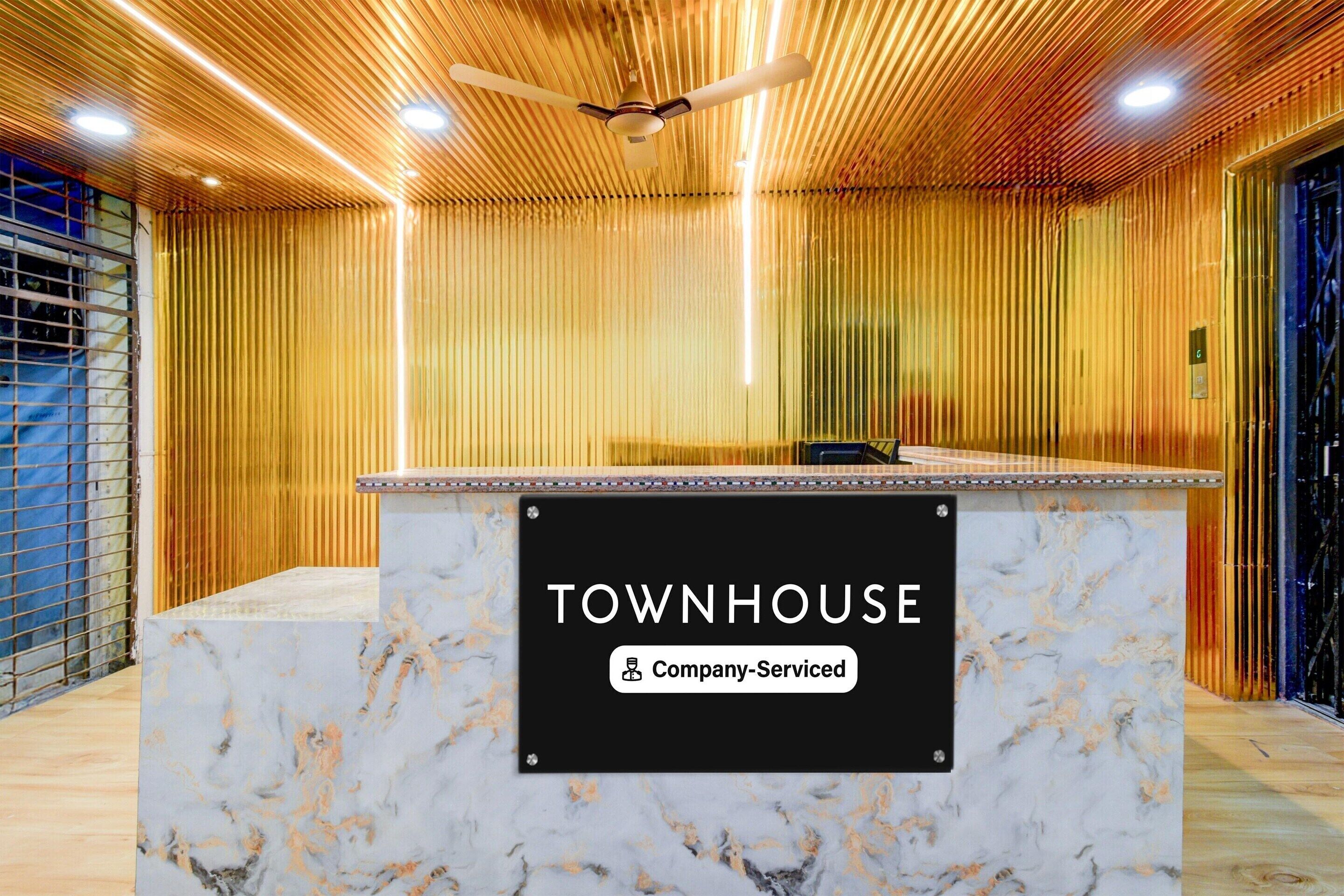 Una mesa de recepción con un cartel que dice 'TOWNHOUSE & Company Serviced'.