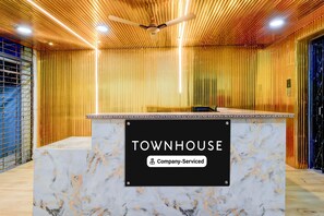 Bancada de recepção com placa indicando 'TOWNHOUSE & Company Serviced'.