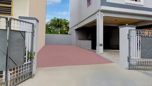 A gated driveway leading to a residential building with a red-tiled entrance. - Premium Vanasthalipuram Near (Hyderabad)