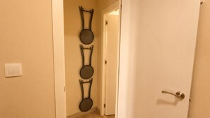 Ein Flur mit einer weißen Tür, einem Lichtschalter und einem an der Wand befestigten Spiegel.