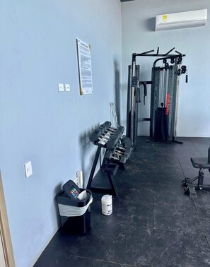 A gym with exercise equipment, a wall-mounted air conditioner, and a whiteboard. - a 10 minutos del centro historico y a 5 minutos de la playa apto amplio 2B / 2B (Cartagena de Indias)