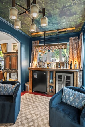 A compact living space with a kitchenette, a bar area, and seating. - Escape to the Arts, Golf Sim, Theater, Hot Tub (Charlotte)