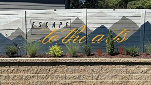 Uma parede com uma placa decorativa que diz 'ESCAPE to the arts'.