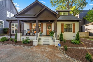 A two-story house with a front porch, a garage, and a well-maintained garden. - Escape to the Arts, Golf Sim, Theater, Hot Tub (Charlotte)