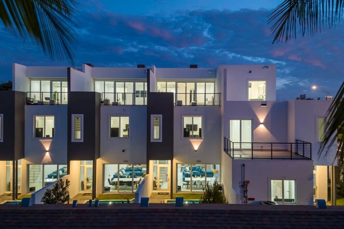 A modern multi-story residential building with balconies, large windows, and a pool area.