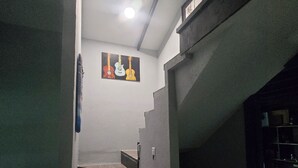 Eine Treppe mit Handlauf, einem Wandbild und einer Deckenleuchte.