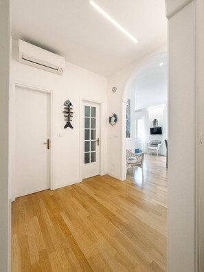 A hallway with wooden flooring, white walls, and a door with a window. - Unique property: 120 square meters - 150 meters from the beach - garage (Lido di Jesolo)