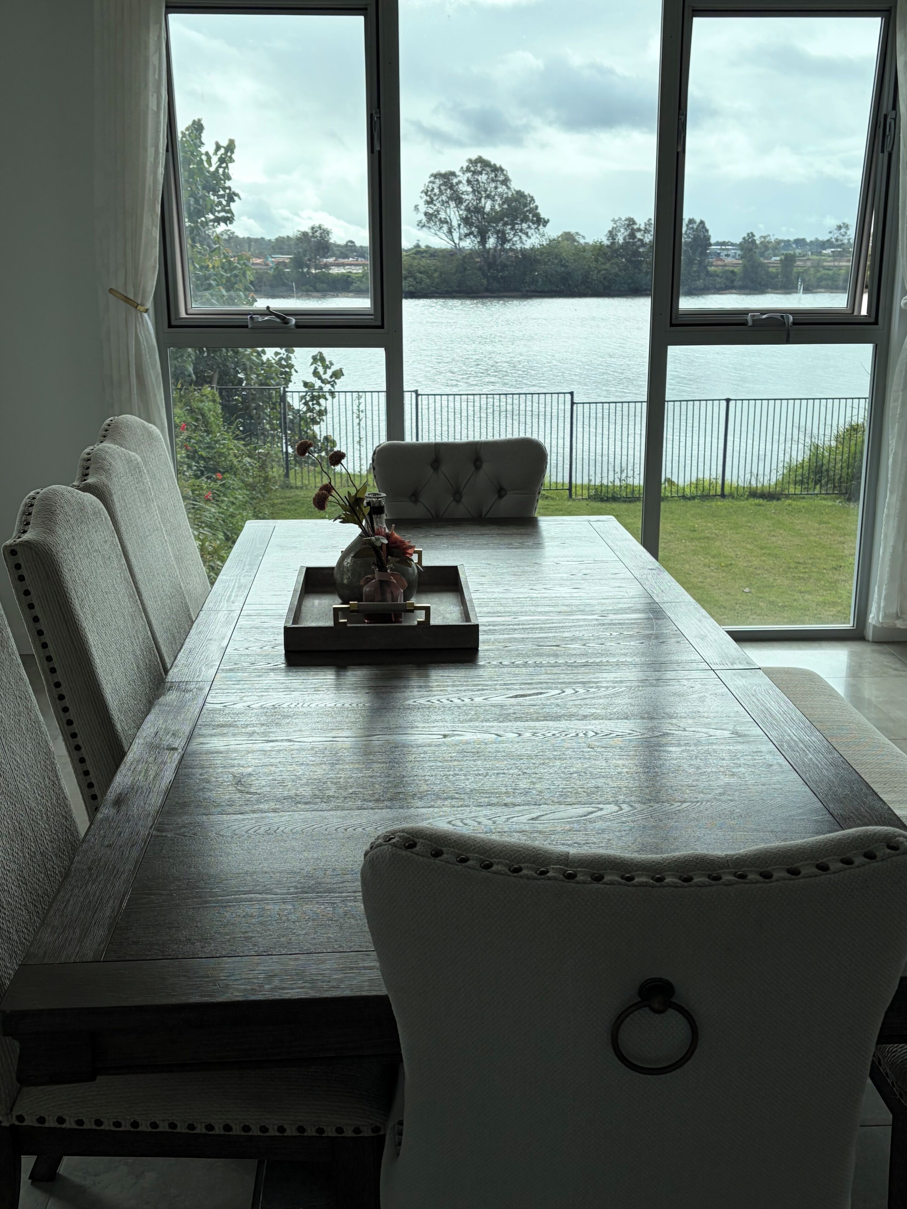 Ein Essbereich mit Seeblick, einer Couch und einem Tisch mit einer Dekoration.