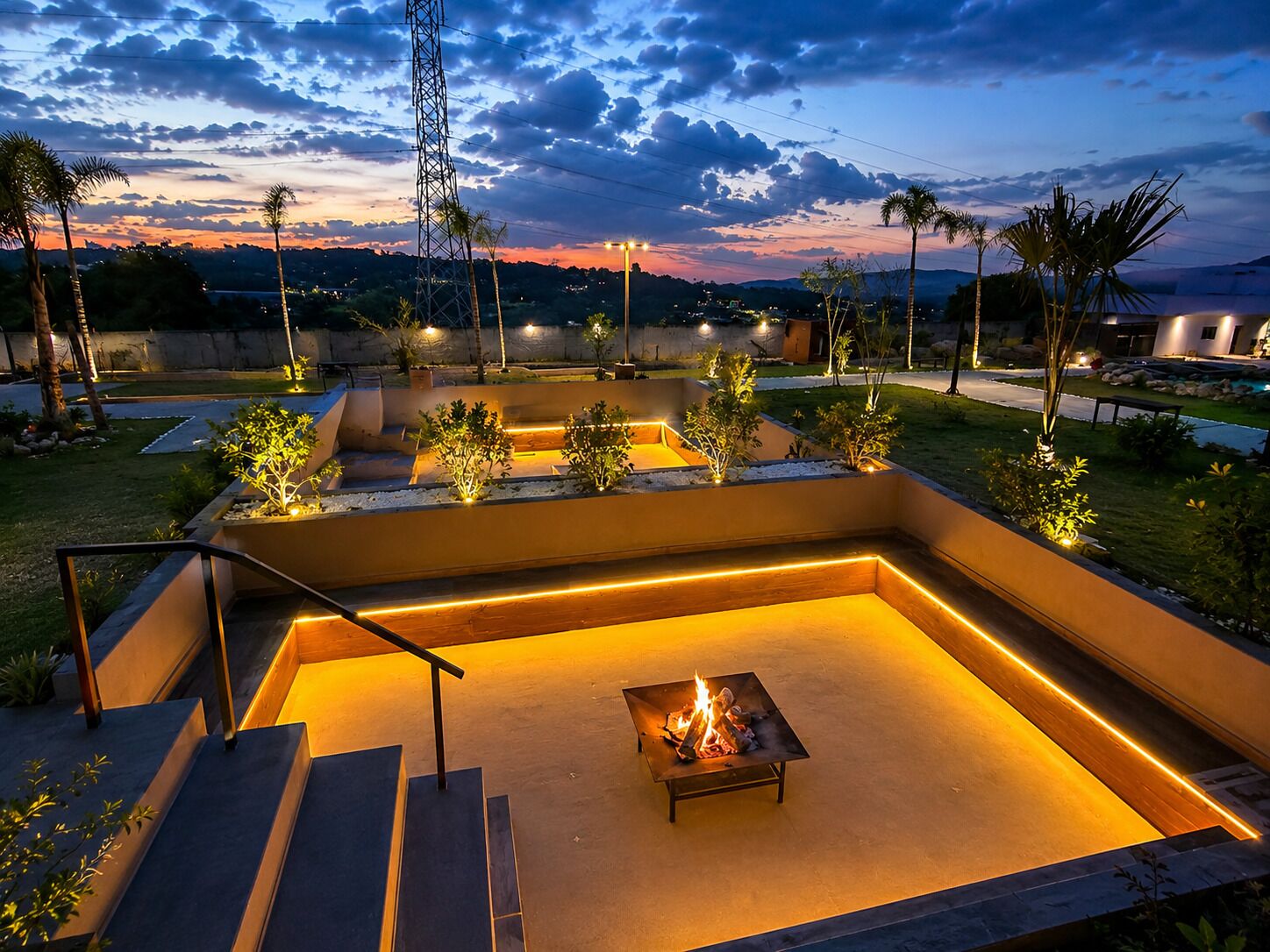A landscaped outdoor area with a fire pit and steps leading to a seating area.