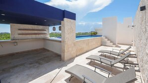 An outdoor patio area with a pool, seating, and a view of the landscape. - Modern 2BR Retreat in Parques Zama w/ Private Pool (Tulum)