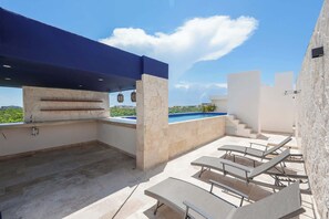 An outdoor patio area with a pool, seating, and a view of the landscape. - Modern 2BR Retreat in Parques Zama w/ Private Pool (Tulum)