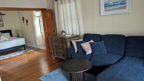 A bedroom with a bed, a dresser, a sofa, and a small round table.