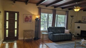 A living room with a sofa, a fireplace, a door with glass panels, and a floor lamp.