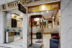 Un charmant hôtel, le « Sweet Dream Inn », avec une façade en marbre et une entrée bien visible.