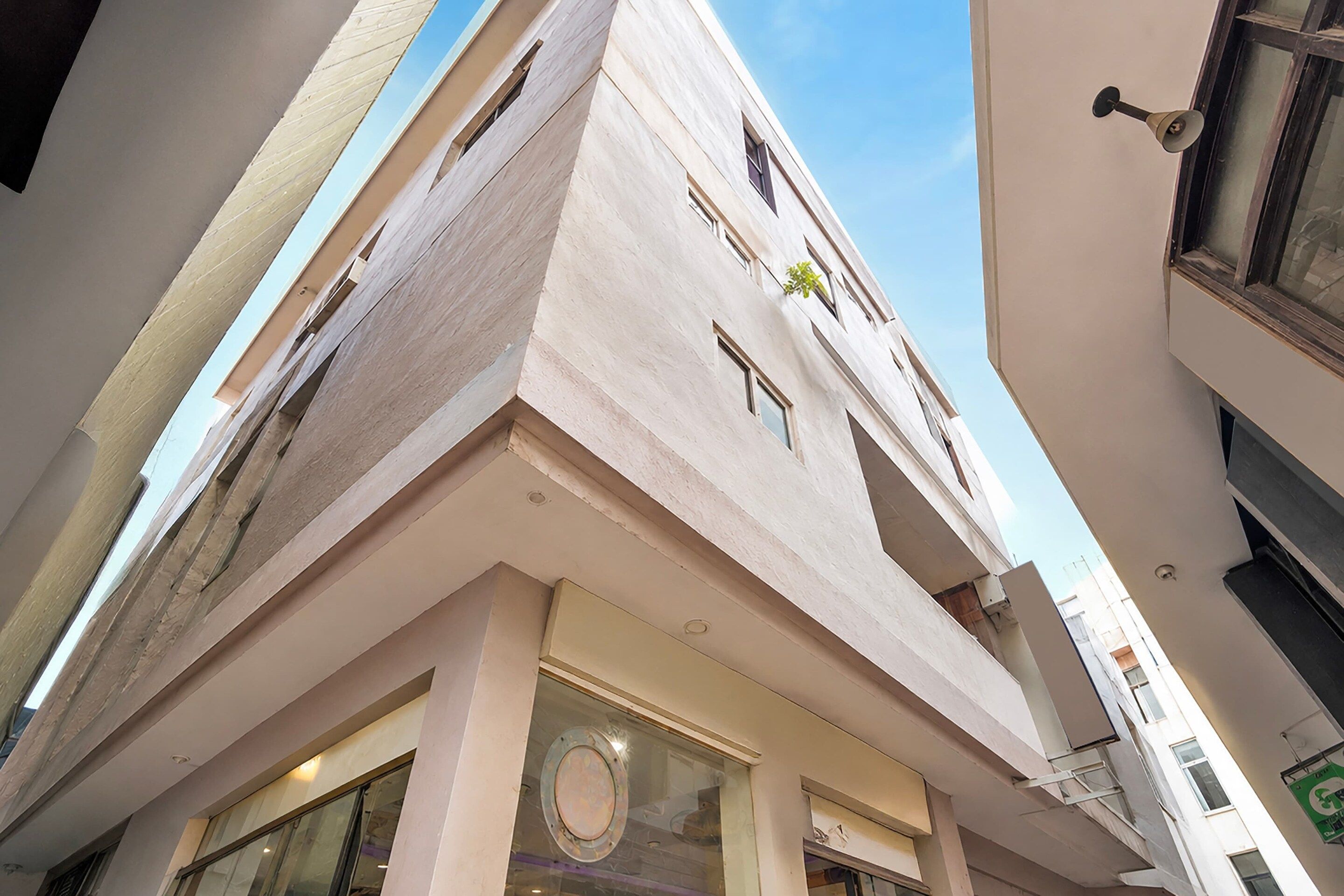 A multi-story building with a flat facade, large windows, and a visible door.