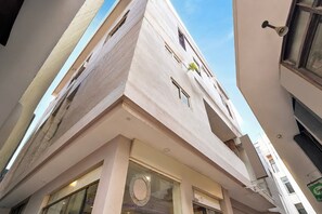 Un immeuble à plusieurs étages doté d’une façade sobre, de grandes fenêtres et d’une porte bien visible.