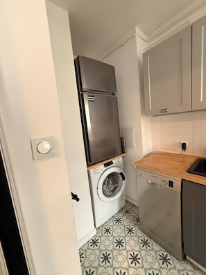 A compact kitchen with a washing machine, a refrigerator, and a dishwasher. - Zlota 3-bedroom apartment in City Center,Pet Friendly (Warszawa)