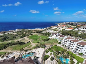 A resort with multiple swimming pools, a golf course, and ocean views. - Private Pool Escape - Luminara at The Reef (Willemstad)