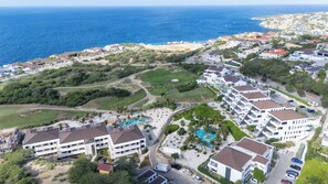 Eine Küstenwohngegend mit Golfplatz, Schwimmbad und modernen Gebäuden.
