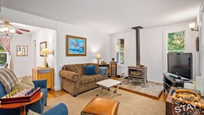 A cozy living room with a sofa, a coffee table, a television, and a fireplace. - Dunning Ranch Guest Buyout by Avantstay 40-acre Vineyard Estate + Spa Tub BBQ + Private Decks (Paso Robles)