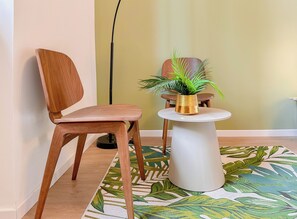 A wooden chair and a small white table with a gold pot and a green plant. - Flatsharing - Gioia Green suite - 1 bedroom (Milan)