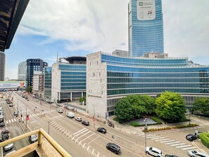 A modern urban street with buildings, vehicles, and a clear sky. - Flatsharing - Gioia Bordeaux suite - 1 bedroom (Milan)