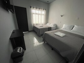 Una habitación de hotel con dos camas individuales, un escritorio y una silla.