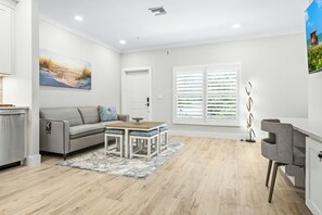 Un salon moderne avec un canapé, une table basse et un tableau accroché au mur.