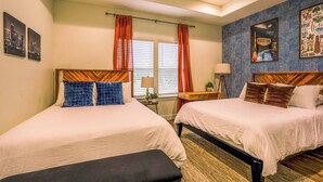 A hotel room with two beds, a bench, a desk, and a patterned wall. - Space City House | Hot Tub + Cinema | Sleep 16+ (Houston)