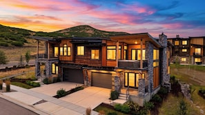A modern two-story house with a garage, large windows, and a stone facade.
