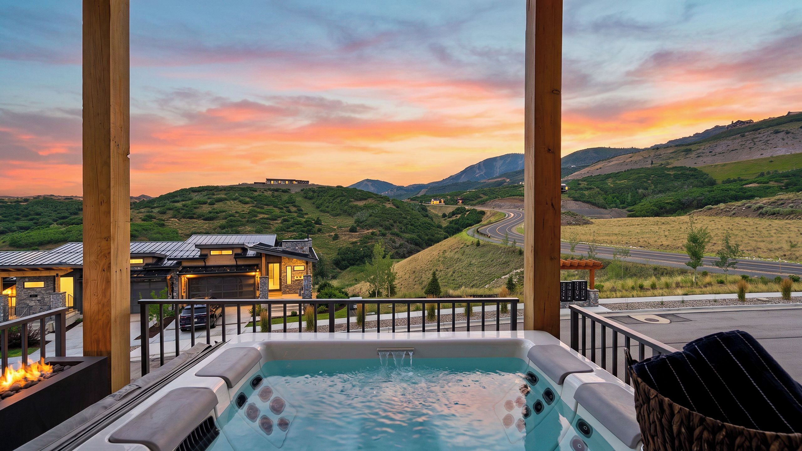 A hot tub with a view of a mountain landscape and a building with a garage.