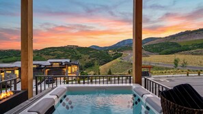 Ein Whirlpool mit Blick auf eine Berglandschaft und ein Gebäude mit Garage.