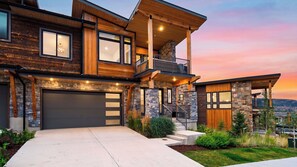 A modern two-story house with a stone facade, a large garage, and a balcony. - Reel & Ridge by Avantstay 2 Hot Tubs + Private Sauna + Movie Room + Fire Pit (Heber City)