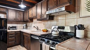 A kitchen with wooden cabinets, a stainless steel range, a dishwasher, and a built-in oven. - A Big Bear View by Avantstay Classic A-frame Hot Tub Deck Fireplace Near Slopes & Marina (Big Bear Lake)