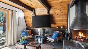 Ein gemütliches Wohnzimmer mit Kamin, Flachbildfernseher und bequemen Sitzmöglichkeiten.