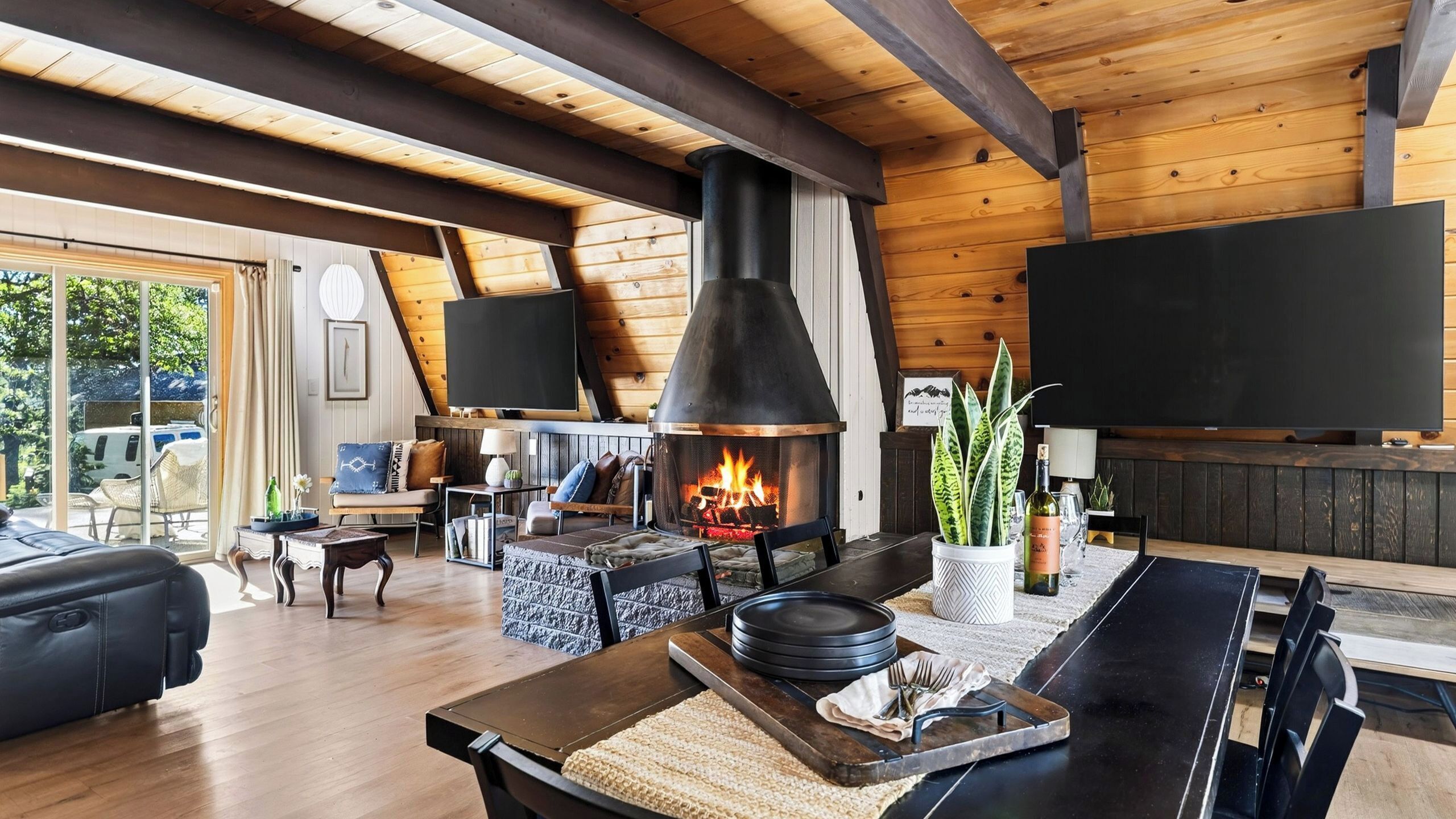 Una sala de estar acogedora con chimenea, vigas de madera, un sofá y un comedor.