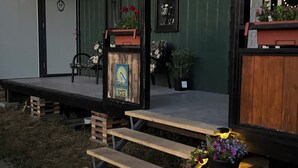 A wooden deck with benches, a small table, and a planter with flowers.