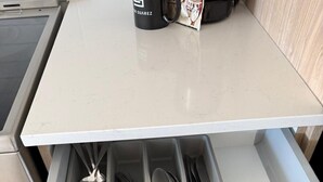 Un tiroir de cuisine contenant des ustensiles et un décapsuleur.