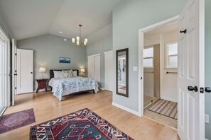 A bedroom with a bed, bedside tables, a chandelier, a painting, and a large mirror. - Heart of Sonoma Wine Country, Kenwood (Kenwood)